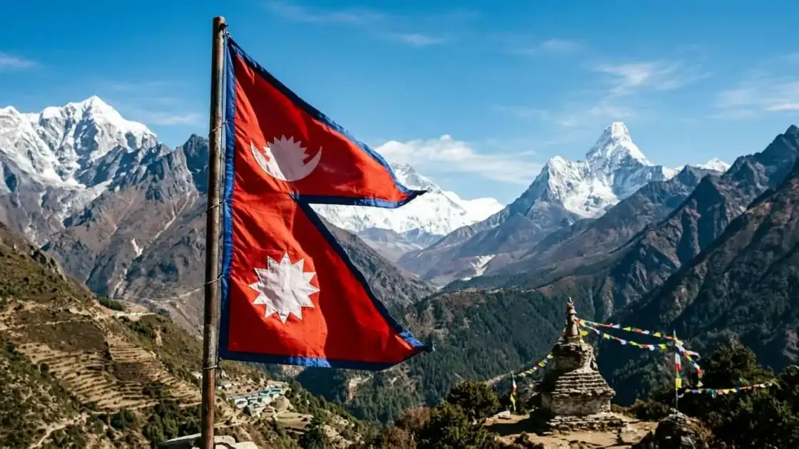 Bandera de Nepal frente a montañas del Himalaya y una estupa con banderas de oración
