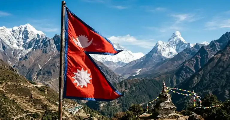 Bandera de Nepal frente a montañas del Himalaya y una estupa con banderas de oración