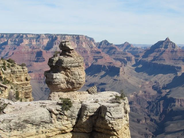South Rim del Gran Cañón: paisajes y miradores Formación rocosa frente a las paredes y profundos cañones del South Rim del Gran Cañón en Arizona
