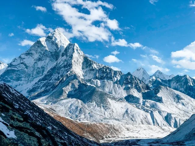Montañas nevadas del Himalaya en Nepal bajo un cielo azul con nubes