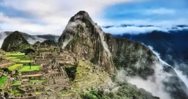 Machu Picchu entre nubes con sus terrazas, construcciones incas y Huayna Picchu al fondo