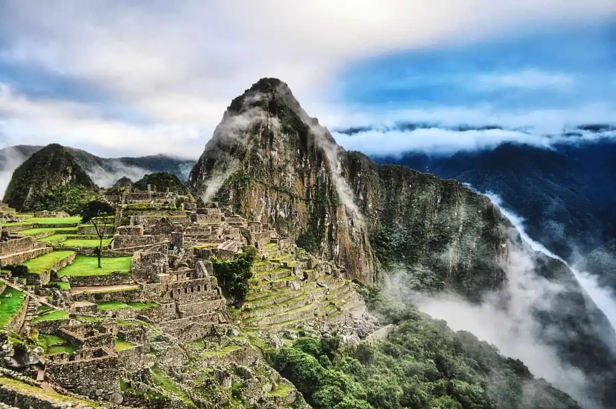 Machu Picchu entre nubes con sus terrazas, construcciones incas y Huayna Picchu al fondo