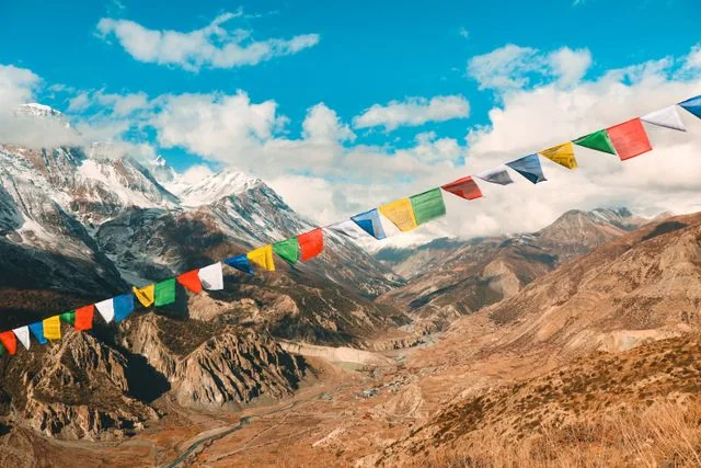 Banderas de oración frente a un paisaje del Himalaya en Nepal con montañas nevadas