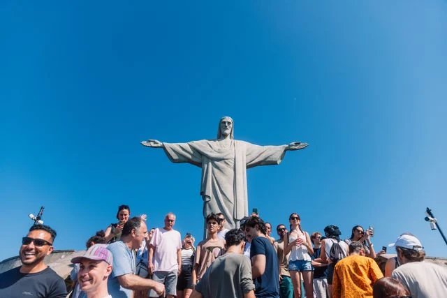 Turistas frente al Cristo Redentor en Río de Janeiro durante un día soleado