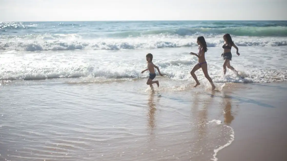 Familia disfruta de la playa durante unas vacaciones de verano junto al mar