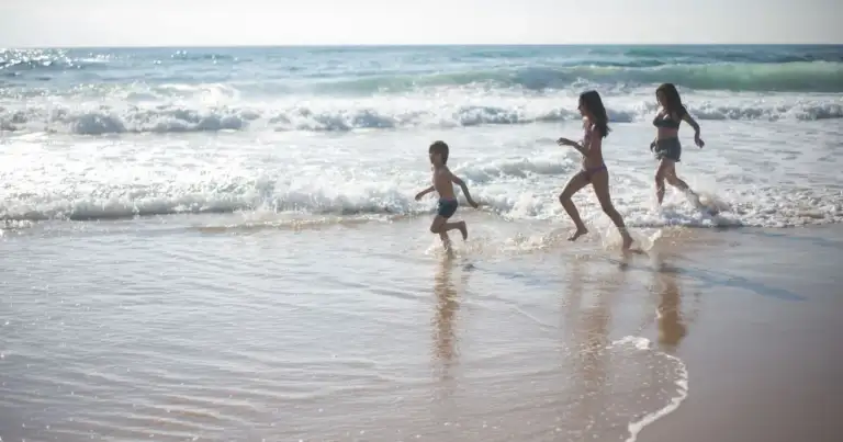 Familia disfruta de la playa durante unas vacaciones de verano junto al mar