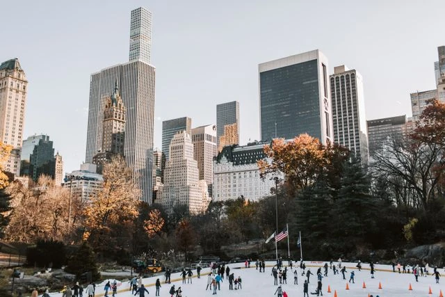 Patinaje sobre hielo en Central Park durante la Navidad en Nueva York Pista de hielo en Central Park con rascacielos de Manhattan al fondo durante la temporada fría